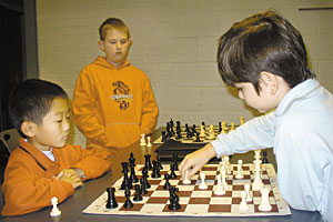 [Kelvin Liu, 7, left, of Beachwood, and Isaac Praul, 11, of Newbury watch Danny Andreini, 7, of Shaker Heights make a move at the Mayfield Village Civic Center.]